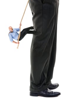 Small businessman climbing big business player's leg