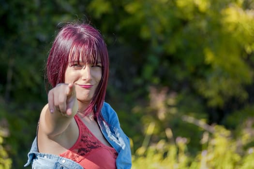 funny portrait of a pretty woman pointing, outdoors