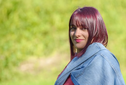portrait of a young woman with green eyes and red hairs, outdoors
