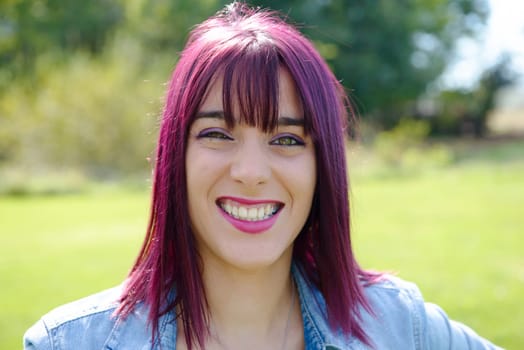 portrait of a young woman with green eyes and red hairs, outdoors