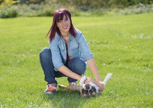 beautiful young woman with her dog french bulldog in the park