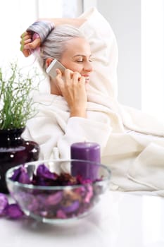 beauty salon,beautiful woman talking on the phone.\nbiological renewal,a woman relaxes in a beauty salon\n