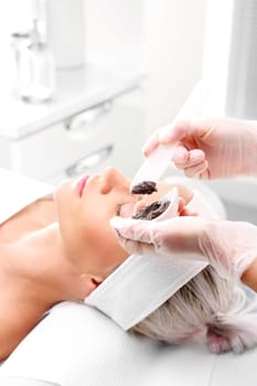 sugar peeling,treatment in a beauty salon.\ncleansing mask,a woman in a beauty salon.\n