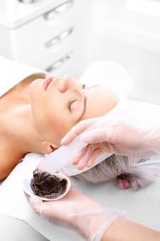 sugar peeling,treatment in a beauty salon.\ncleansing mask,a woman in a beauty salon.\n