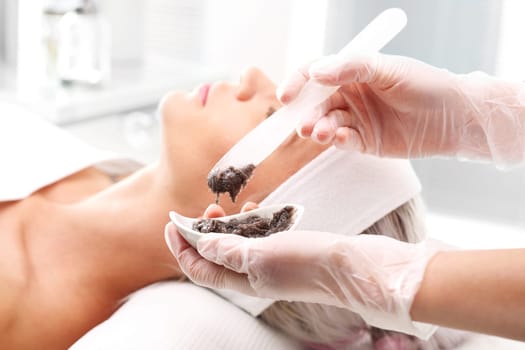 sugar peeling,treatment in a beauty salon.\ncleansing mask,a woman in a beauty salon.\n