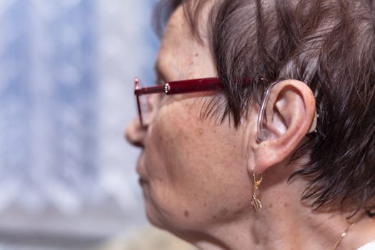 Profile of a senior woman with hearing aid.