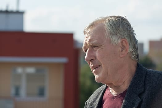 Closeup of senior man and building urban background.