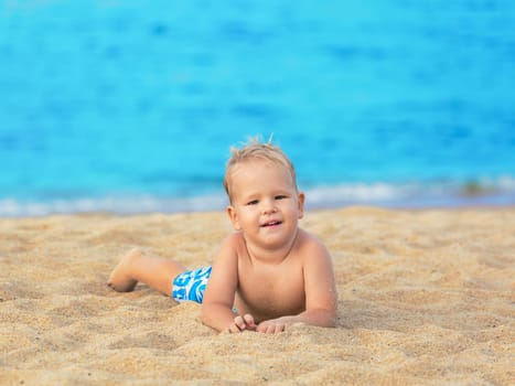 Cute boy relaxing on the tropical beach