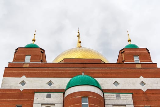 Muslim temple with green and gold domes
