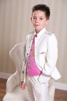 Young boy with serious expression standing and looking at camera in his First Holy Communion.