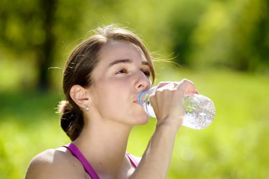 beautiful athletic girl drinking water after exercising