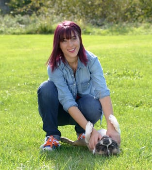 beautiful young woman with her dog french bulldog in the park