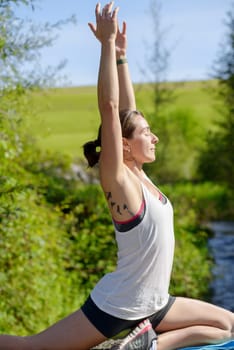 beautiful young fitness woman doing exercise in countryside