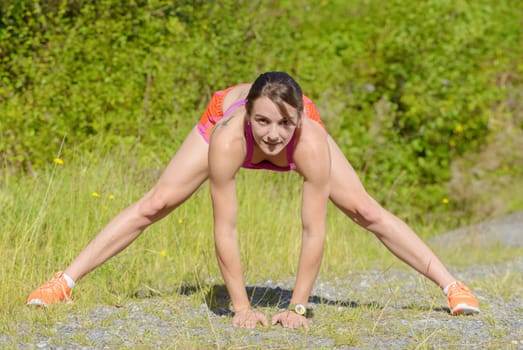 beautiful young fitness woman doing exercise in countryside