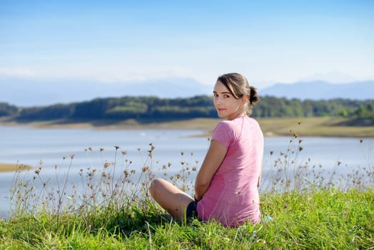 portrait of young sporty woman with pink sportswear, back view