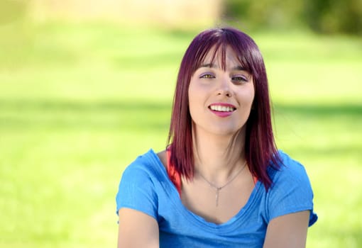 portrait of a beautiful young woman with a blue shirt, outdoors