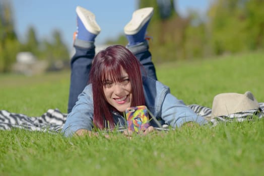 beautiful young woman in jeans lying on the grass, in park
