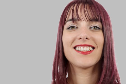 portrait of a beautiful young woman with green eyes on grey background