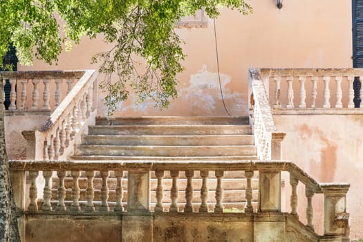 Mediterranean old stone staircase on an abandoned ancient building in the south with a stone wall..