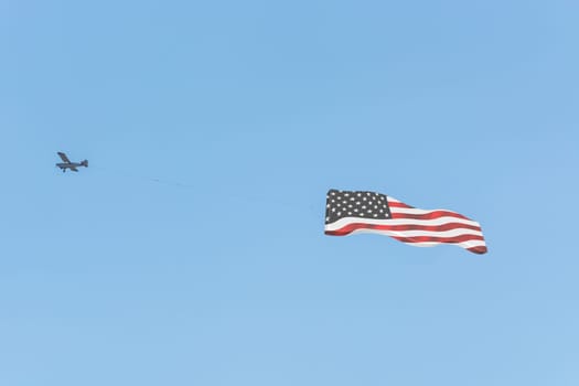 Banner tow,small powered aircraft with tow banner for advertising.. Here is the flag of America...