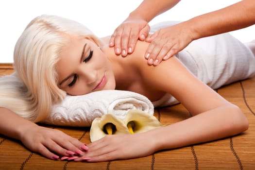 Beautiful young woman relaxing at spa getting therapeutic pampering shoulder massage.