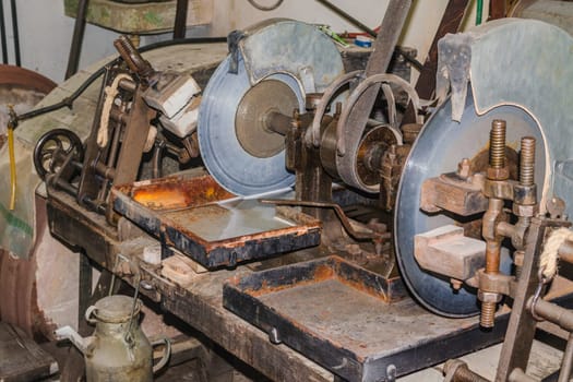 Old grindstone. Old stone cutting machine with water cooling..
