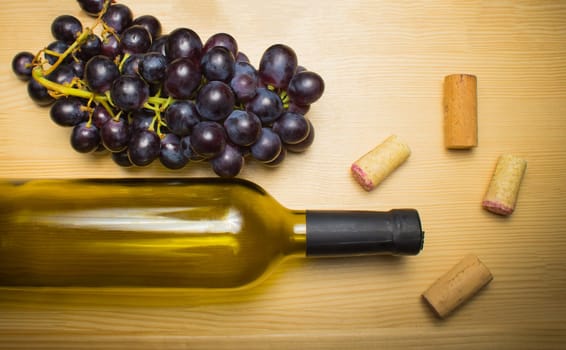 The empty bottle of wine with corkscrews and glass of coconut on wooden background