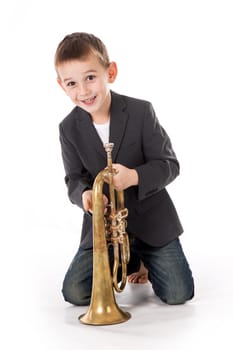 young boy blowing into a trumpet against white background