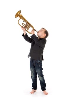 young boy blowing into a trumpet against white background