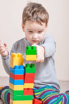 Playing little boy with colored cubes