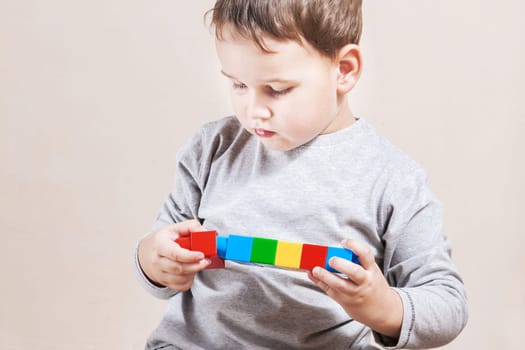 Playing little boy with colored cubes
