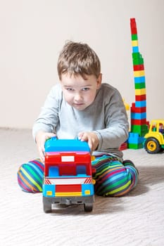 Playing little boy with colored cubes