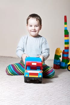 Playing little boy with colored cubes