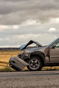 Car Crashed after Accident with a field and cloudy sky.