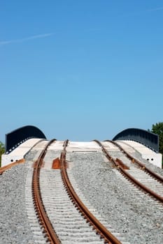 A newly built bridge and rail line for trams with rails,ballast and railings.