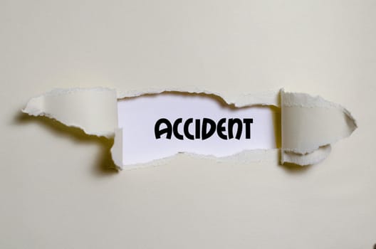 The word accident appearing behind torn paper
