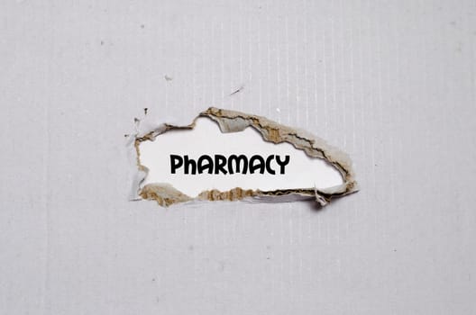 The word pharmacy appearing behind torn paper