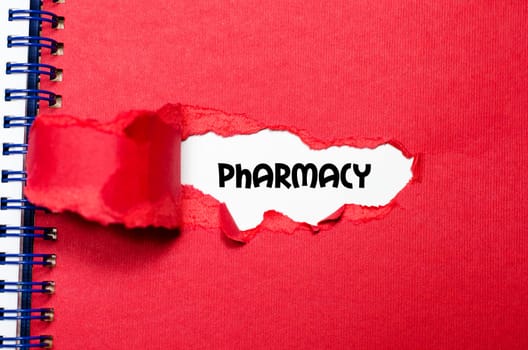 The word pharmacy appearing behind torn paper