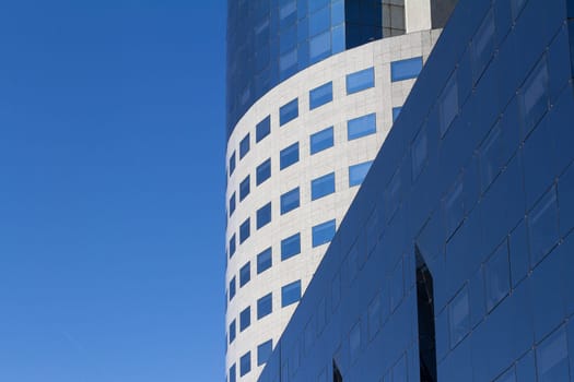 Detail of round city office building in downtown Bucharest with blue sky in the background