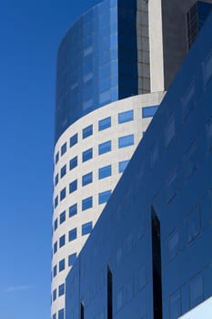 Detail of round city office building in downtown Bucharest with blue sky in the background