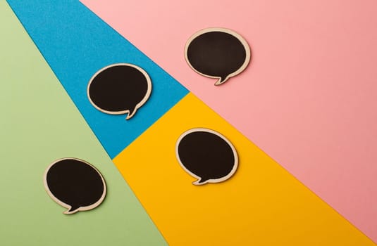 Top view of round chalk board speech bubbles on colored papers, metaphor, concept for communication
