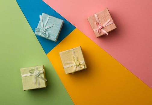 top view of colored gift boxes on minimal background of different kinds of paper textures