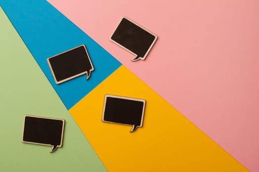 Top view of square chalk board speech bubbles on colored papers, metaphor, concept for communication