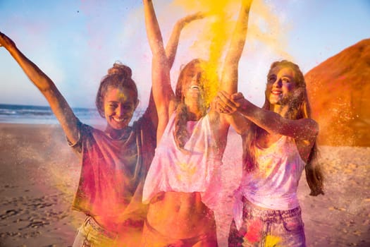 Teenagers playing with colored powder on the beach