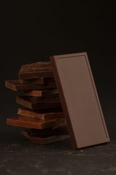 Front view of square shaped chocolate pieces isolated on dark background
