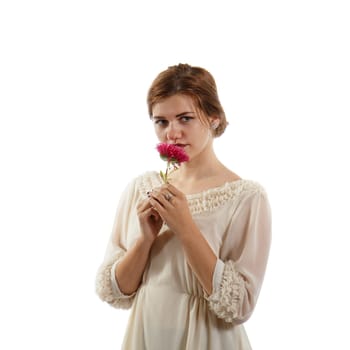 A girl in a white dress holding a magenta flower