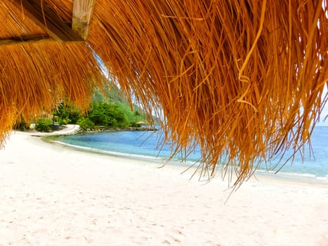 The Caribbean tropical beach. View through the thatched roof