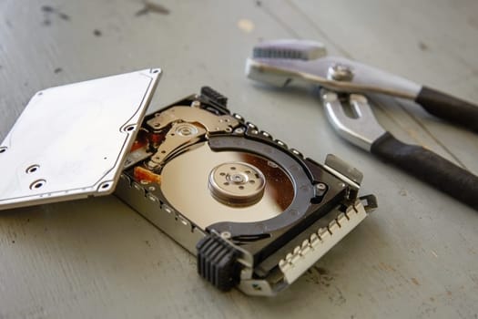 Broken and Destroyed Hard Drive Disk on Wooden Table.