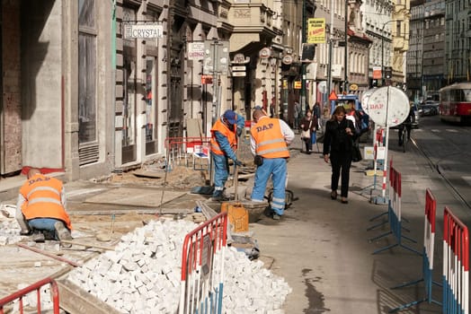 Construction workers renew a cobblestone footpath in downtown Prague