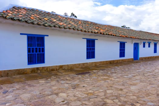 White colonial building with blue windows in Villa de Leyva, Colombia